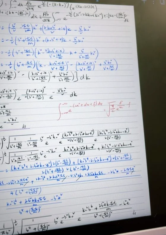 Handwritten iPad notes: a Gaussian wave packet evolved in time, with long Gaussian integrals in blue and red ink.