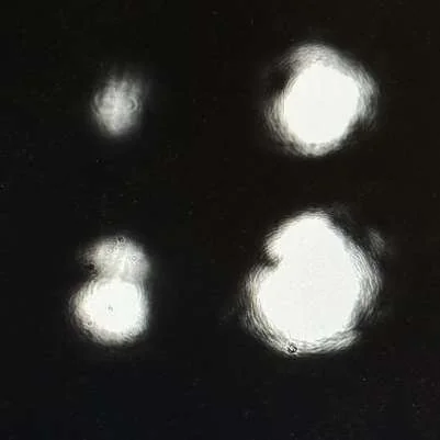 Four diffraction spots on a camera image, smeared and misshapen.